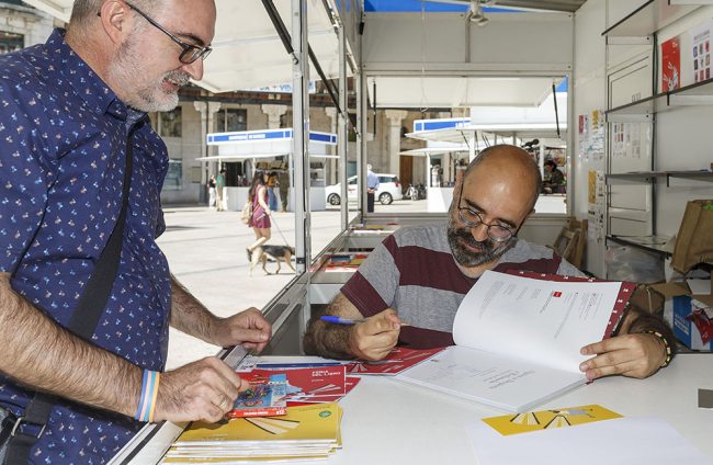 Óscar Esquivias firma un ejemplar a un lector en la pasada Feria del Libro de Burgos. SANTI OTERO
