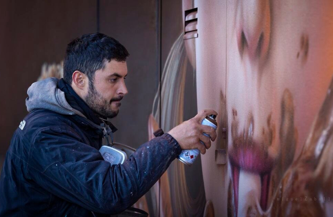 Christian Sasa mientras pintaba el grafiti seleccionado por Street Art Cities. MIGUEL ZABALLA