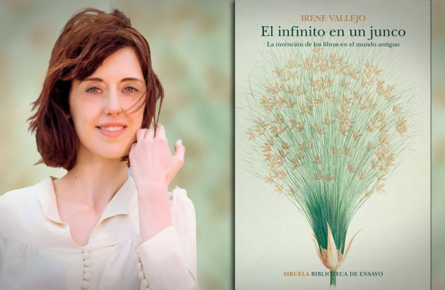 Irene Vallejo, junto a la portada de 'El infinito en un junco'. J FUEMBUENA / SIRUELA