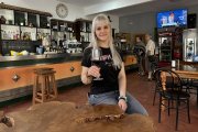 Dana posa junto a la mesa de madera de roble que ha fabricado su padre