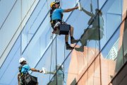 Dos obreros realizan labores de limpieza en la fachada de un edificio de la capital.