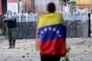 Un hombre con la bandera venezolana en la capital, Caracas.-UESLEI MARCELINO (REUTERS)