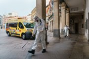 Personal municipal con mascarillas desinfectando los accesos al Ayuntamiento. ECB