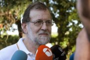 El presidente del Gobierno Mariano Rajoy atiende a los medios de comunicacion durante su paseo por las orillas del rio Umia a su paso por la localidad de Ponte Arnelas en Ribadumia Pontevedra en el inicio de sus vacaciones.-SALVADOR SAS (EFE)