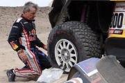 Carlos Sainz (Mini), en pleno trabajo para cambiar una rueda pinchada.-AFP / FRANCK FIFE
