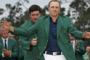Jordan Spieth se enfunda la chaqueta verde de manos de Bubba Watson, vencedor en el 2014.-Foto: REUTERS / BRIAN SNYDER