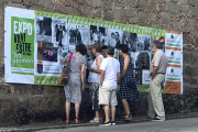 Varias personas contemplan las fotografías, que se han colocado en 18 puntos del pueblo.-OMITSU ISSEY