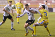 El defensa de la Arandina Garcés agarra de la camiseta a  Fito Miranda, autor del segundo gol capitalino.-ISRAEL L. MURILLO