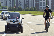 Un coche eléctrico circula junto a un ciclista.-ISRAEL L. MURILLO