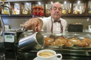 Un camarero sirve un café con leche a un cliente.-QUIQUE PALA