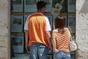 Una pareja observa anuncios de pisos de una inmobiliaria.-RAÚL G. OCHOA