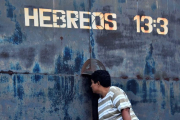 Una mujer observa por una rendija en una puerta del centro penitenciario de Tela, este sábado.-EFE / JOSÉ VALLE