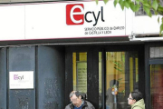 Dos personas esperan a la puerta de una oficina del Ecyl.-ECB