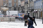 Unos jóvenes juegan con la nieve en la plaza de La Flora.-RAÚL G. OCHOA