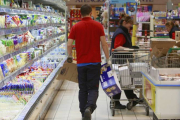 Un empleado repone género en un expositor refrigerado de lácteos, uno de los artículos de mayor consumo en la cesta de la compra, en la que la marca burgalesa Campofrío es una de las más consumidas.-RAÚL OCHOA