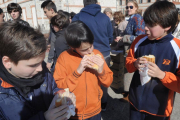 Tres niños comen con apetito la merienda más solidaria del año.-ISRAEL L. MURILLO