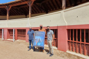 Javier Ajenjo junto al alcalde, José Antonio Cámara, y el concejal, Juan José Peña posan con el cartel en la plaza de toros de Huerta. L.V.