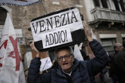 Uno de los participantes en la manifestación contra la despoblación del casco antiguo y el aumento descontrolado del turismo en Venecia.-AFP / MARCO BERTORELLO