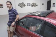 Jaime Uvedoble, junto al coche que ocupa el centro de la sala que acentúa el carácter urbano de la colección que viste las paredes.-Santi Otero