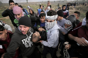 Manifestantes palestinos portan el cuerpo sin vida de Yasser Sokar, en la franja de Gaza.-EFE / MOHAMMED SABER