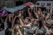 La muchedumbre traslada el féretro de Razan Najjar, la enfermera que ha muerto por los disparos hebreos. / La muchedumbre traslada el féretro de Razan Najjar, la enfermera que ha muerto por los disparos hebreos.-HAITHAM IMAD (EFE)