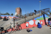 Los artistas del colectivo SiO2 dando los últimos toques al mural de la zona de juegos de la plaza del Hangar. ECB