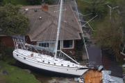Una embarcación empotrada contra una casa a causa de los efectos del Florence a su paso por New Bern, en Carolina del Norte.-STEVE HELBER (AP)