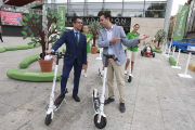 García y De la Rosa junto a los patinetes eléctricos que hay en el Paseo Sierra de Atapuerca.-RAÚL G. OCHOA