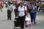 Venezolanos llevan comestibles por el puente Simón Bolívar, desde Cucuta (Colombia, de regreso a San Antonio de Tachira (Venezuela), el 17 de julio.-AFP / GEORGE CASTELLANOS