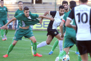 Pepe Delgado lucha por un balón con un jugador del Racing, ayer, en El Plantío.-ISRAEL L. MURILLO