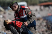 Un policía turco traslada el cuerpo sin vida de un niño tras otro naufragio en el Egeo.-AFP / OZAN KOSE