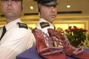 Guardias de seguridad custodian unos zapatos con rubís y platino valorados en 1,47 millones de euros, en Harrods.-EPA