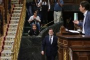 Mariano Rajoy vuelve a su escaño tras unos minutos fuera del hemiciclo mientras Pablo Iglesias habla en la tribuna.-JUAN MANUEL PRATS
