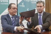 Ramón Sobremonte y Javier Lacalle intercambian las carpetas que contienen el convenio.-SANTI OTERO