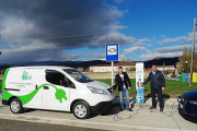 El concejal -centro- realizando la recarga de un vehículo en uno de los dos puntos instalados en la localidad.-ECB