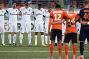 Los jugadores del PSG y del Lorient, durante el minuto de silencio previo al partido-AFP / JEAN-SEBASTIEN EVRARD