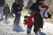 Una familia de refugiados se dirige a la frontera de Macedonia con Serbia.-