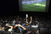 Aficionados siguiendo un partido de fútbol televisado en un cine madrileño.-AGUSTÍN CATALÁN
