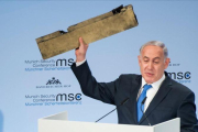 Netanyahu muestra el trozo del supuesto drone iraní que Israel asegura derribó la semana pasada mientras sobrevolaba su territorio.-AFP/ LENNART PREISS