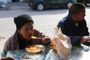 Una mujer y un hombre se alimentan en un comedor social de Villa Fiorito, en Buenos Aires, el pasado mes de junio.-RODRIGO GARCÍA (EFE)