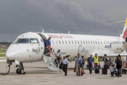 Un grupo de pasajeros desciende del avión en el aeropuerto de Villafría.-SANTI OTERO