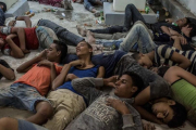 Supervivientes del naufragio duermen en una comisaría tras ser rescatados.-AP / EMAN HELAL