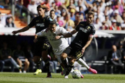 Cristiano Ronaldo cae el suelo entre dos defensas del Granada.-AGUSTÍN CATALÁN
