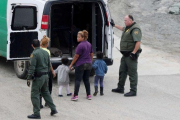 Oficiales de fronteras detienen a una mujer y su hijo integrantes de la caravana de inmigrantes de Centro América.-REUTERS MOHAMMED SALEM
