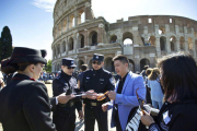 Dos agentes chinos, junto a dos italianos, revisan la documentación de un grupo de turistas chinos, en el exterior del Coliseo, en Roma, este lunes.-AP / JIN YU