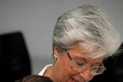 Dos enfermeras sujetan a un niño para administrarle una inyección.-