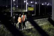 Tres inmigrantes se encaminan por las vías del tren con la intención de acceder al Eurotúnel, cerca de Calais.-REUTERS