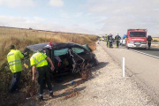 Los agentes de la Benemérita inspeccionan el vehículo siniestrado poco antes de su retirada.-G. G.