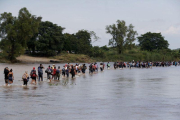 Integrantes de la segunda caravana de migrantes  en su mayoria hondurenos  cruzan a pie el rio Suchiate.-EFE