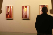 Un visitante observa algunos de los cuadros de la serie 'Luz del amanecer'.-Raúl Ochoa